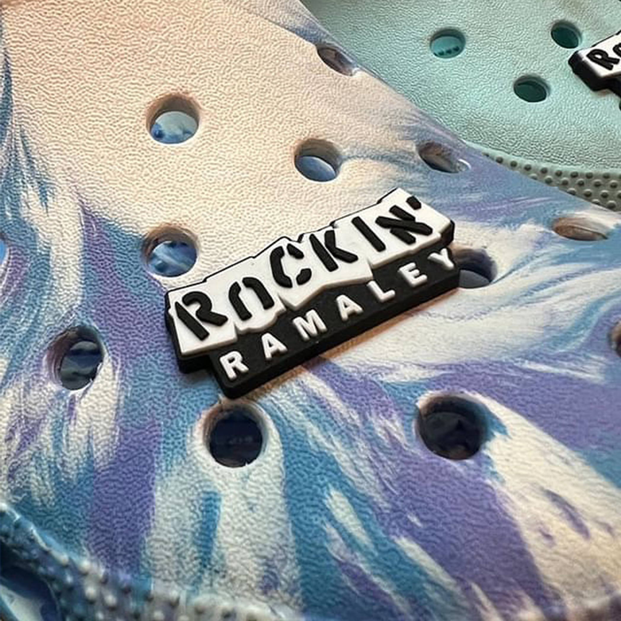 Close up photo of Rockin' Ramaly Croc Charm on a tiedie Croc